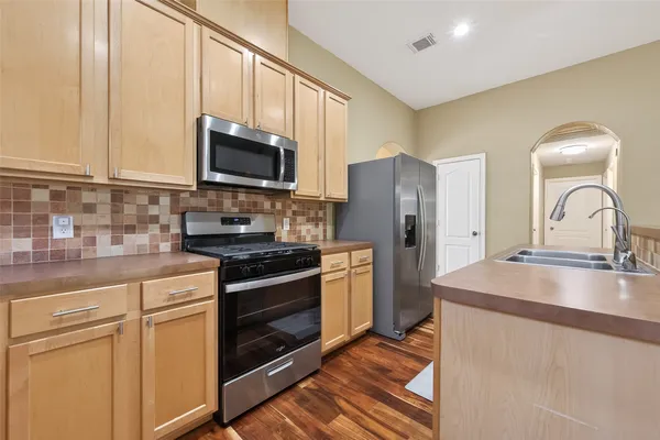 a kitchen with granite countertop a sink stainless steel appliances and cabinets