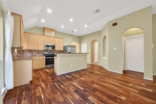 a kitchen with stainless steel appliances granite countertop a refrigerator and a stove top oven