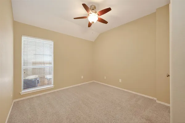an empty room with chandelier fan