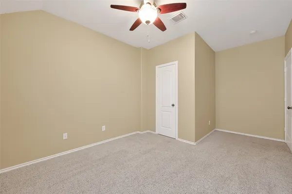 an empty room with a window and a ceiling fan