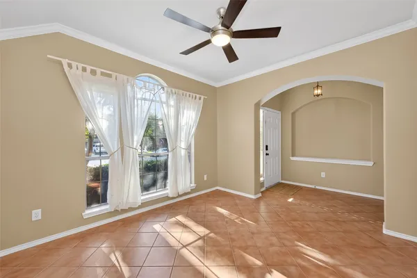 a view of a big room with windows and chandelier fan