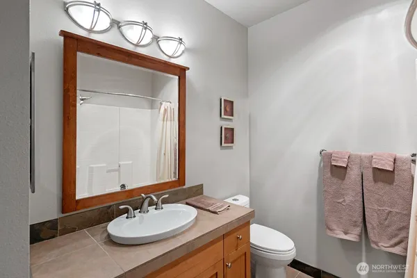 a bathroom with a sink vanity mirror and toilet