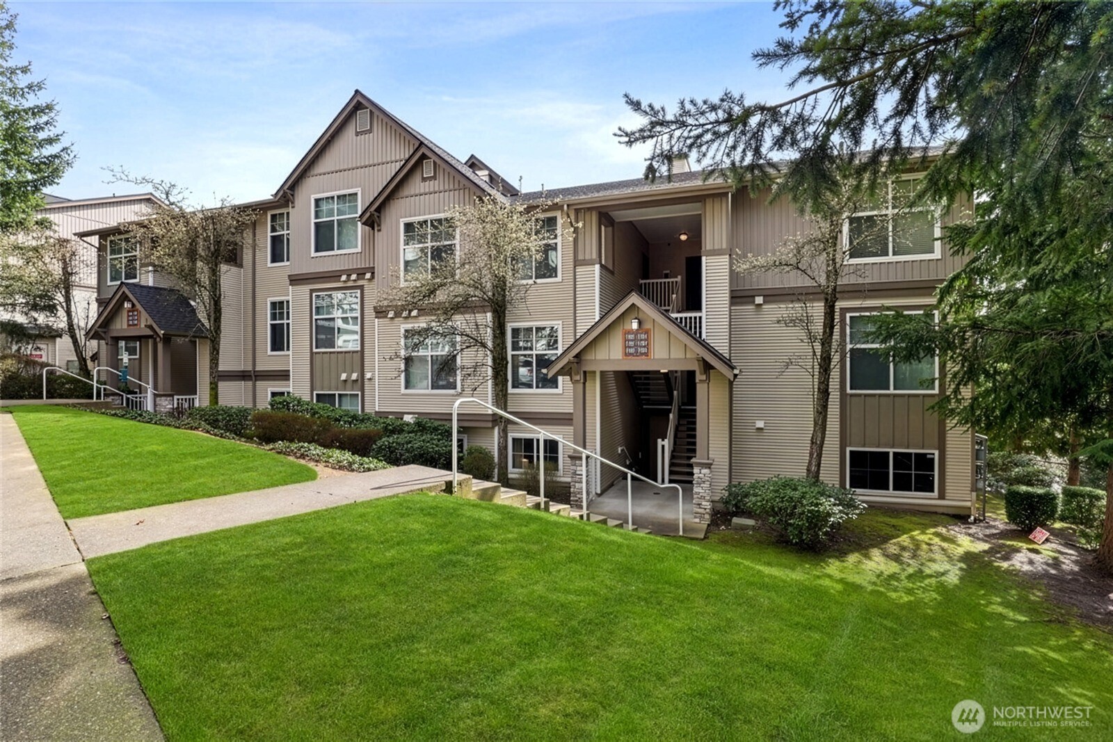23420 Southeast Black Nugget Road, Unit F302 Issaquah, WA 98029 - Photo 3 of 19 a front view of a house with a yard and garage