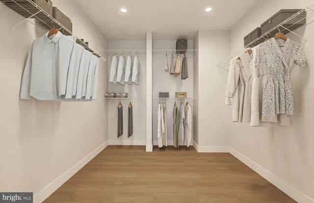 a view of walk in closet with clothes and shoes