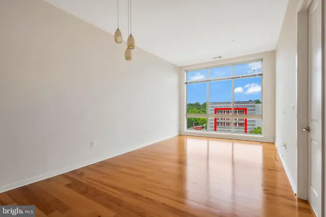 a view of a hallway with wooden floor and window