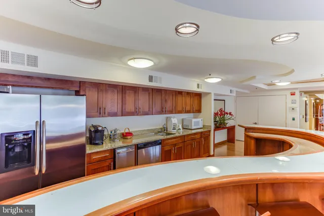 a kitchen with stainless steel appliances granite countertop a sink and a refrigerator