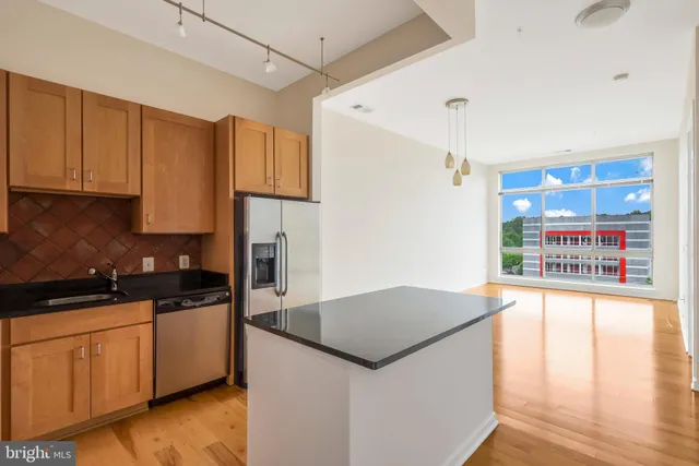 a kitchen with stainless steel appliances granite countertop a sink and a refrigerator