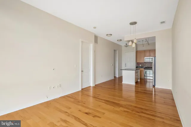 a view of empty room with wooden floor