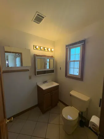 a bathroom with a toilet sink and mirror