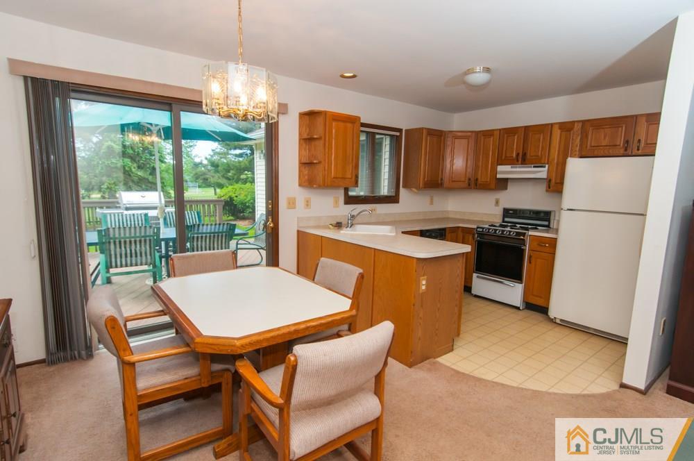 40 Higgins Road Old Bridge, NJ 08857 - Photo 23 of 46 a kitchen with a table chairs and a refrigerator