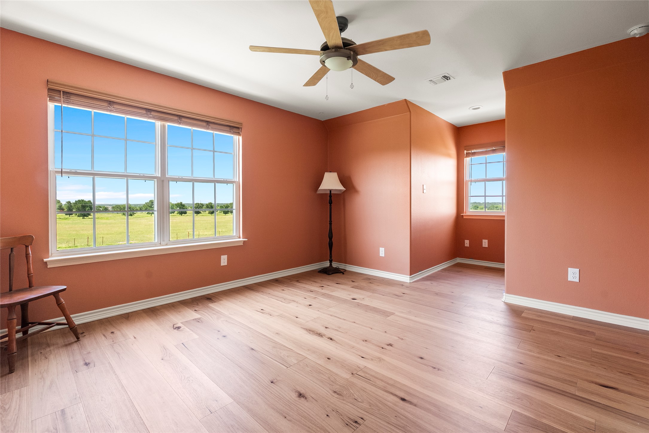 928 Upper Elgin River Road Elgin, TX 78621 - Photo 26 of 40 Spacious room featuring light wood-finish flooring, multiple windows, and a ceiling fan