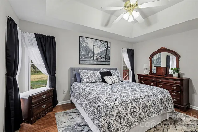 a bedroom with a large bed and a flat tv screen on dresser