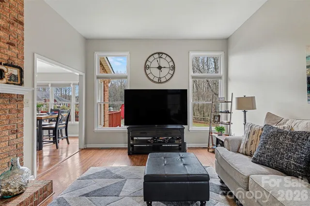 a living room with furniture a flat screen tv and a clock