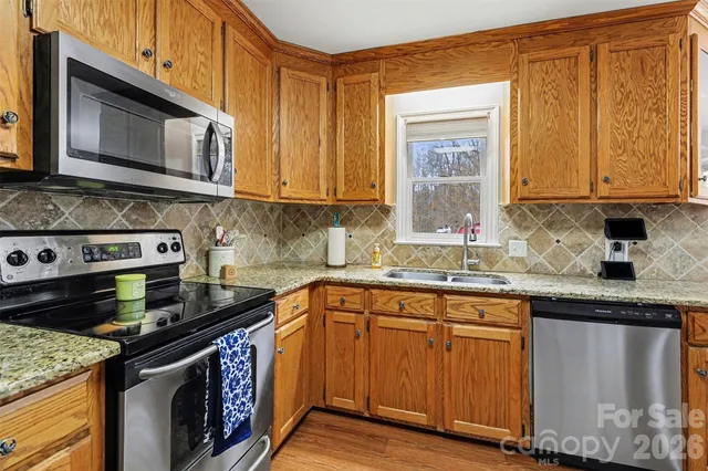 a kitchen with stainless steel appliances granite countertop a sink stove and microwave