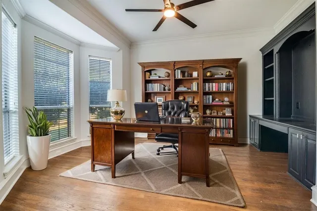 a view of a workspace with furniture and a window