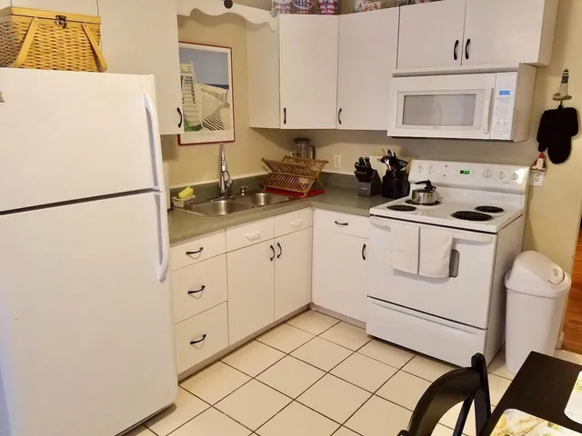 a kitchen with a refrigerator a stove a sink and cabinets