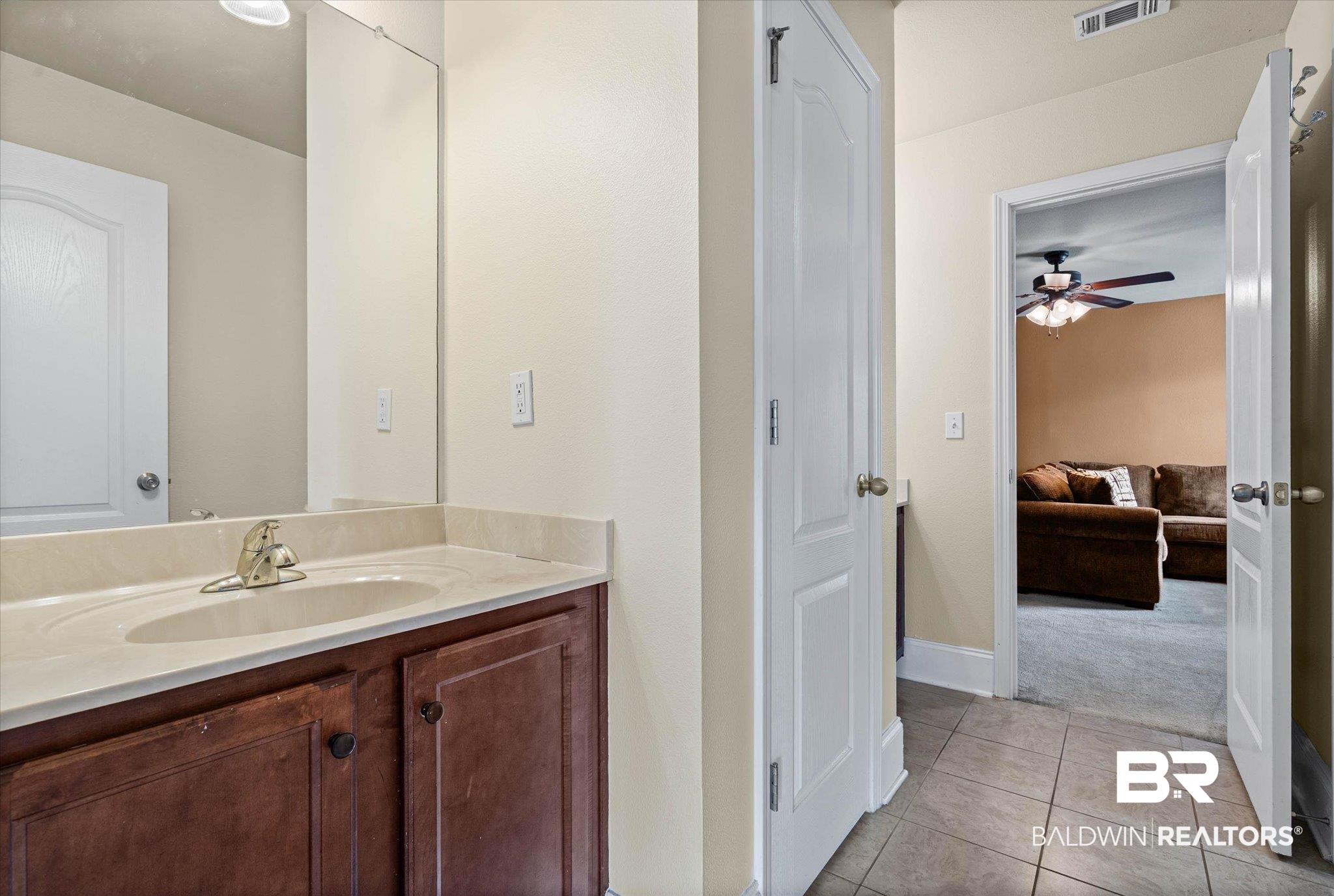 585 Sheffield Avenue Foley, AL 36535 - Photo 19 of 45 Bathroom vanity with a light-toned countertop, integrated sink, and wood-finish cabinetry
