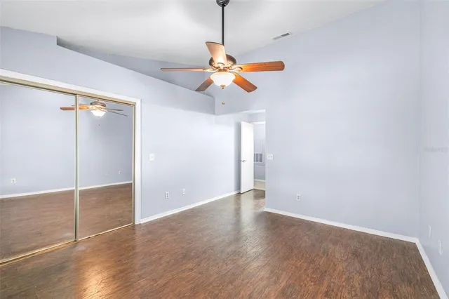 a view of empty room with wooden floor