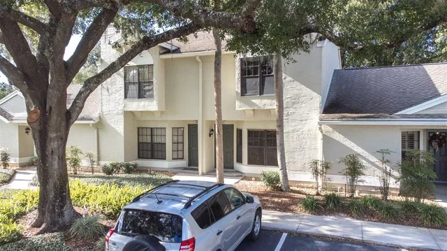 a front view of house with yard outdoor seating and large tree