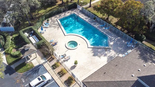 an aerial view of a house with a yard and a large tree