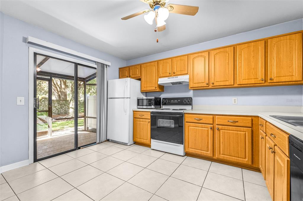 5100 Burchette Road, Unit 4102 Tampa, FL 33647 - Photo 10 of 47 a kitchen with stainless steel appliances granite countertop a stove top oven a sink dishwasher and a refrigerator with wooden cabinets
