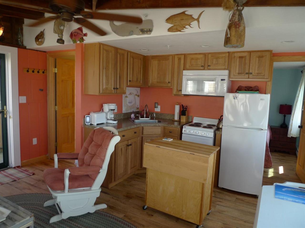 522 Shore Road, Unit 4 Truro, MA 02666 - Photo 5 of 12 a room with furniture a refrigerator and wooden floor