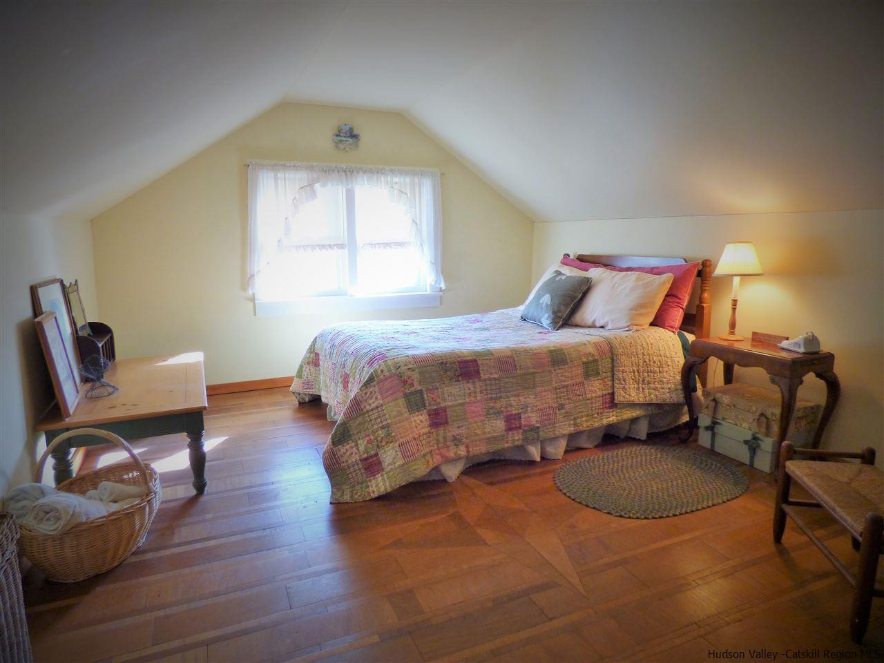 21 Crittenden Street Wallkill, NY 12589 - Photo 17 of 28 a bedroom with a bed a chair and potted plant on the dresser