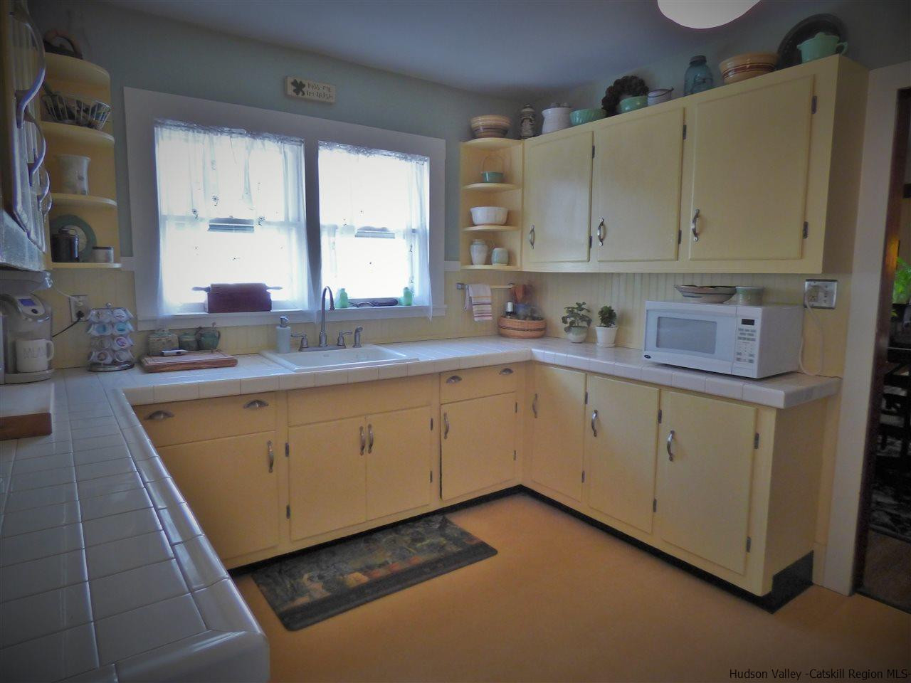 21 Crittenden Street Wallkill, NY 12589 - Photo 7 of 28 a kitchen with white cabinets sink and window