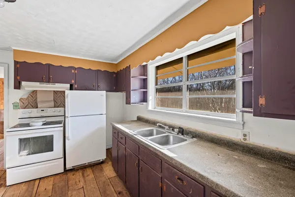 an empty room with wooden floor and ceiling fan