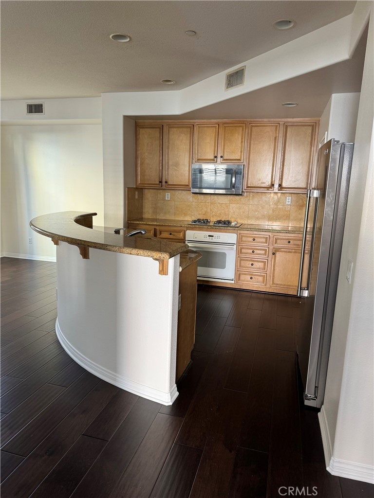 2986 Arbolitos Lane, Unit B Simi Valley, CA 93063 - Photo 4 of 36 a kitchen with stainless steel appliances granite countertop a stove a sink and a refrigerator