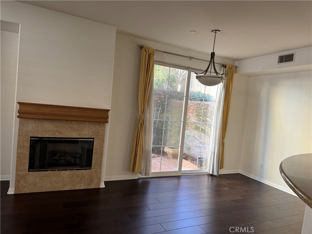 2986 Arbolitos Lane, Unit B Simi Valley, CA 93063 - Photo 7 of 36 a view of an empty room with wooden floor fireplace and a window