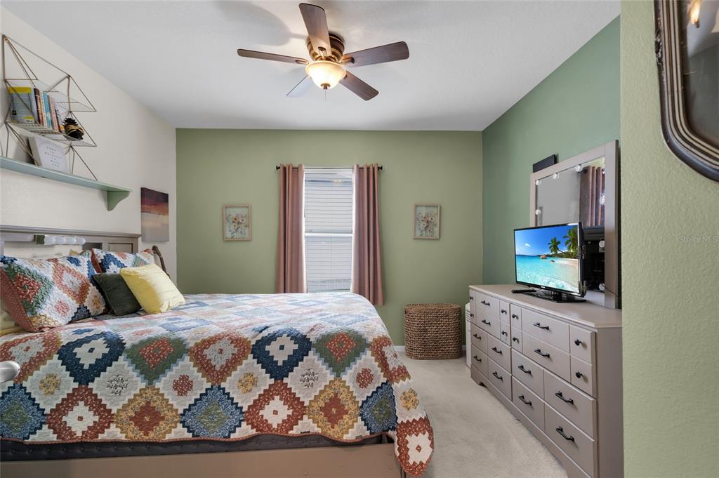 3016 Northeast 43rd Road Ocala, FL 34470 - Photo 19 of 35 a bedroom with a bed and a flat tv screen on dresser