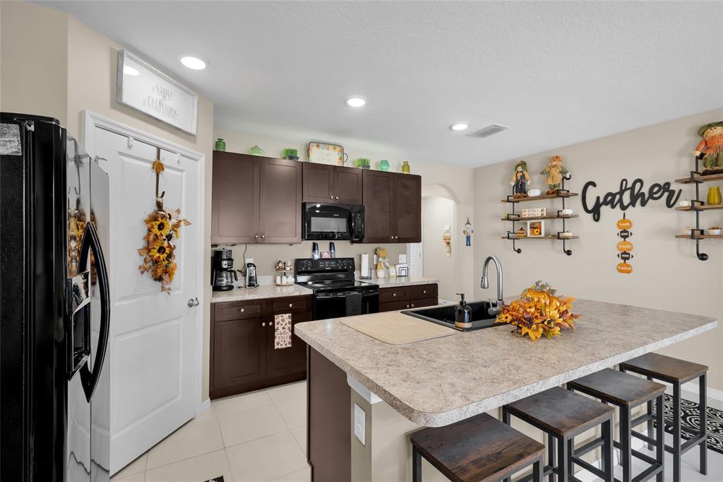 3016 Northeast 43rd Road Ocala, FL 34470 - Photo 8 of 35 a kitchen with granite countertop a refrigerator and microwave