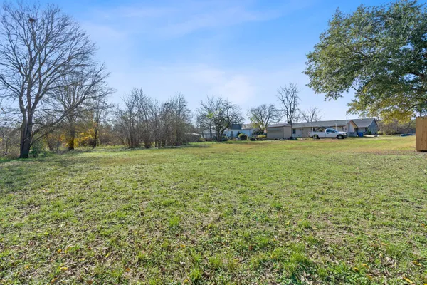 a view of a field with trees in the background