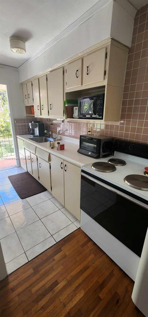 60 Northwest 79th Street, Unit 28 Miami, FL 33150 - Photo 10 of 28 a kitchen with stainless steel appliances granite countertop a stove a sink and a microwave