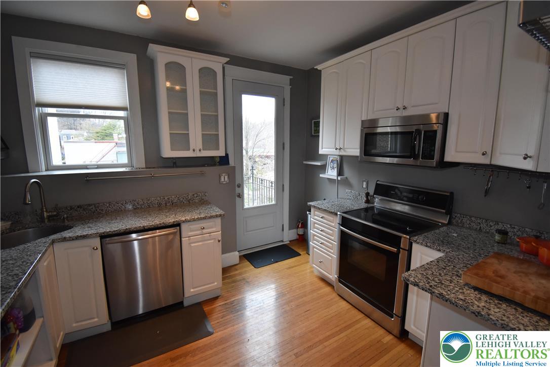 134 North 3rd Street Easton, PA 18042 - Photo 25 of 38 a kitchen with granite countertop wooden cabinets stainless steel appliances and a sink