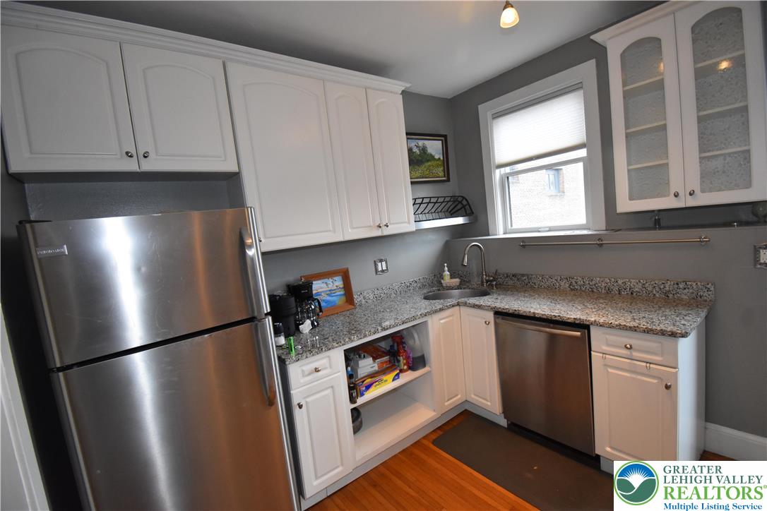 134 North 3rd Street Easton, PA 18042 - Photo 26 of 38 a kitchen with stainless steel appliances granite countertop a refrigerator a sink a stove and white cabinets with wooden floor