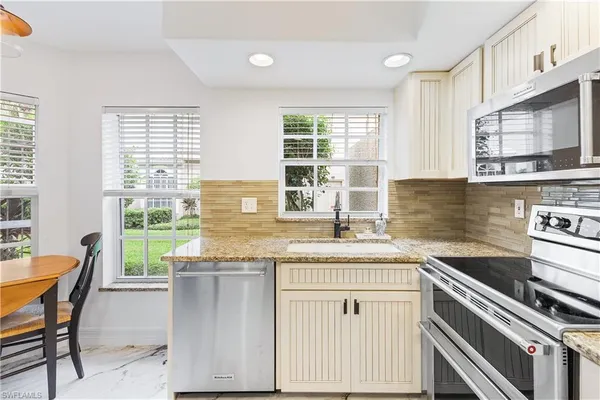 a kitchen with stainless steel appliances granite countertop a stove a sink and a microwave