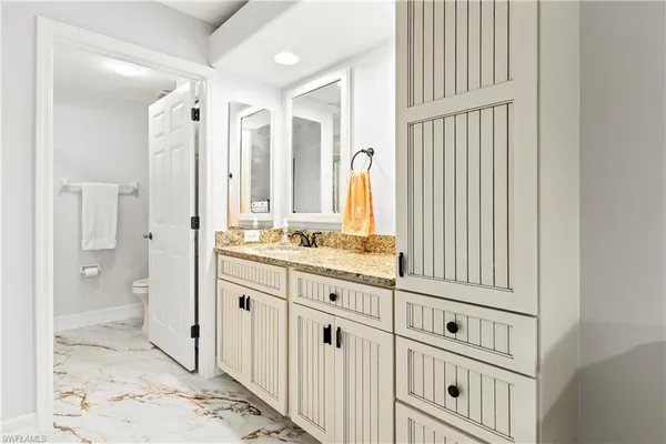 a bathroom with a granite countertop sink and a mirror