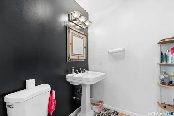 a bathroom with a sink toilet and a mirror
