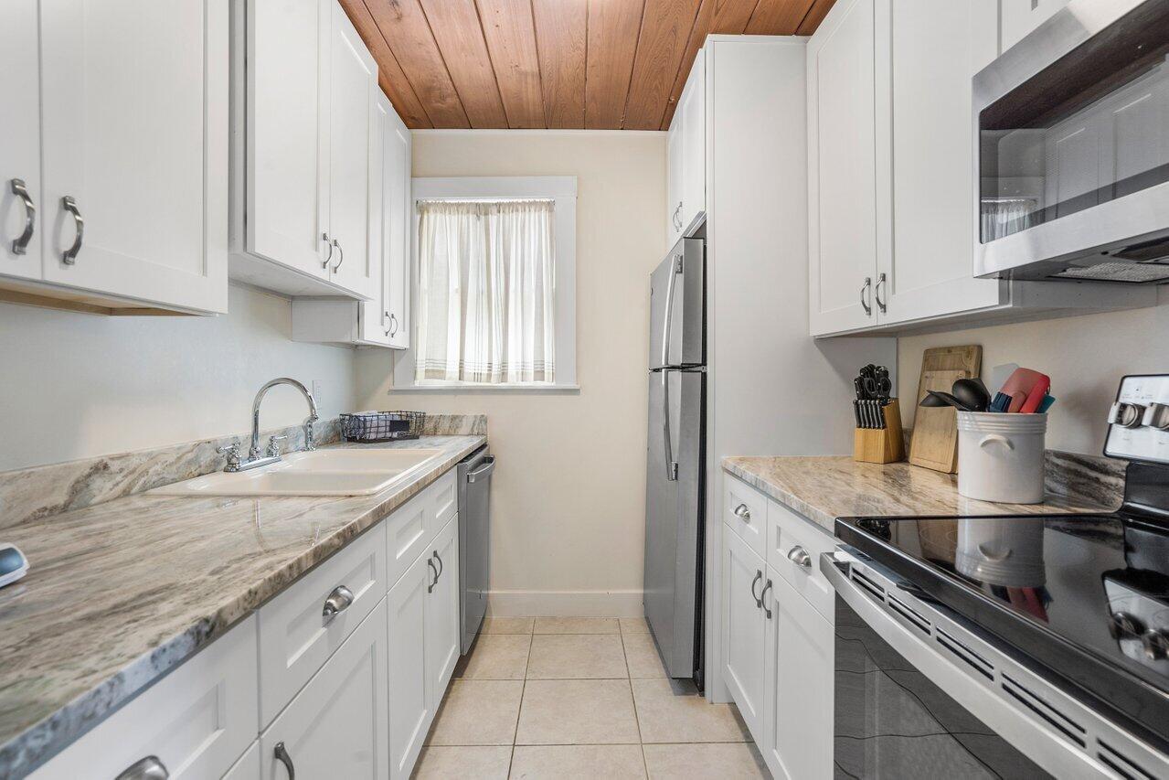102 Southeast 7th Avenue, Unit VILLA 1 Delray Beach, FL 33483 - Photo 13 of 27 a kitchen with stainless steel appliances granite countertop a sink stove and cabinets