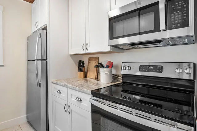 a kitchen with stainless steel appliances granite countertop a refrigerator and a stove
