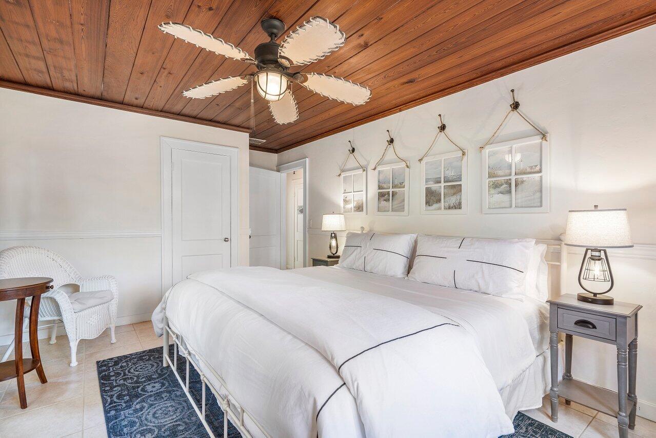 102 Southeast 7th Avenue, Unit VILLA 1 Delray Beach, FL 33483 - Photo 17 of 27 a bedroom with a large bed and a chandelier