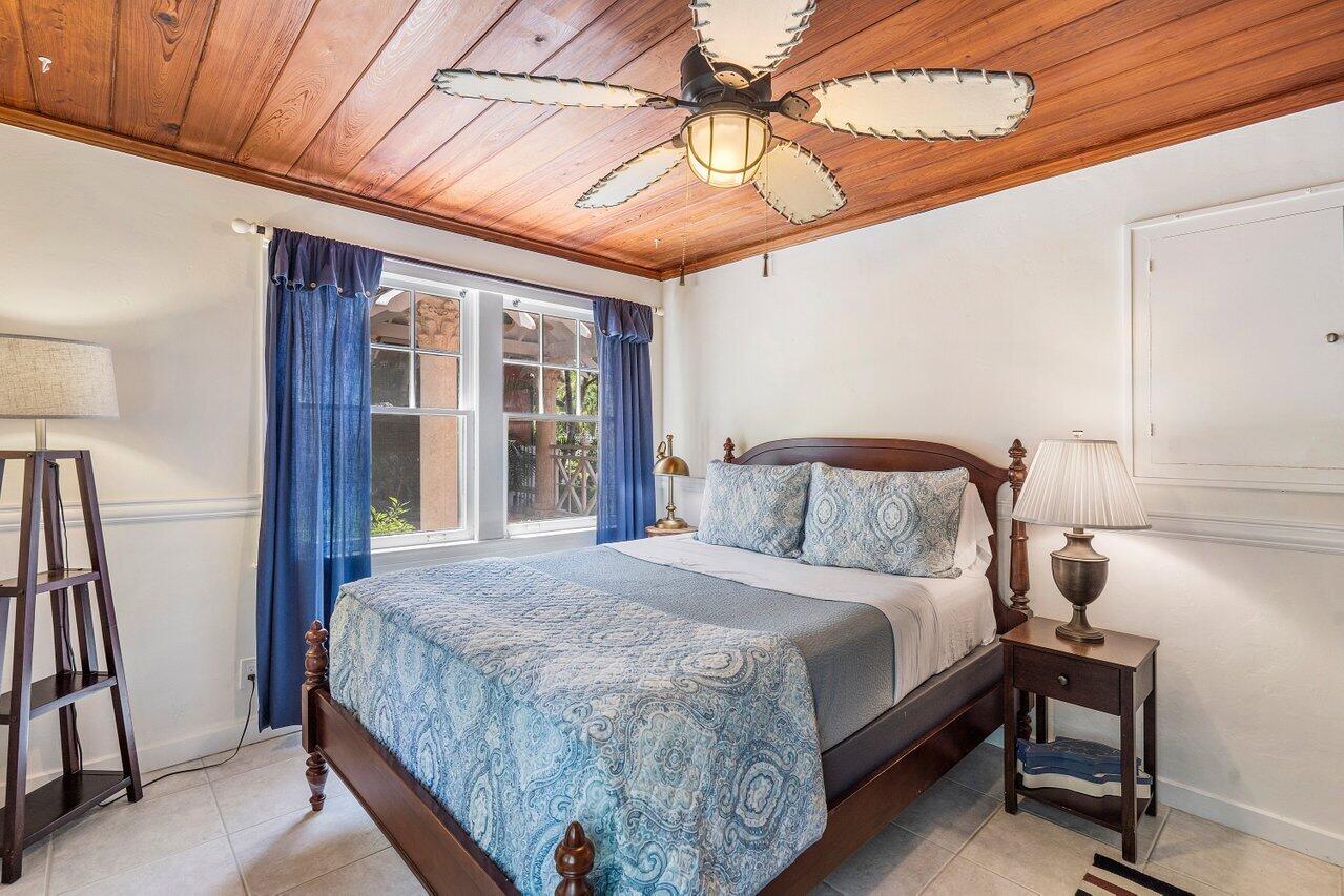 102 Southeast 7th Avenue, Unit VILLA 1 Delray Beach, FL 33483 - Photo 19 of 27 a bedroom with a bed and a chandelier