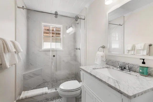 a bathroom with a granite countertop sink toilet and shower