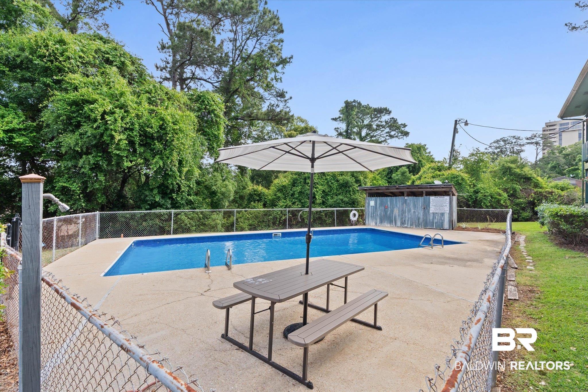 500 Grant Street, Unit C210 Daphne, AL 36526 - Photo 25 of 26 In-ground swimming pool featuring a concrete deck and surrounding chain-link fencing