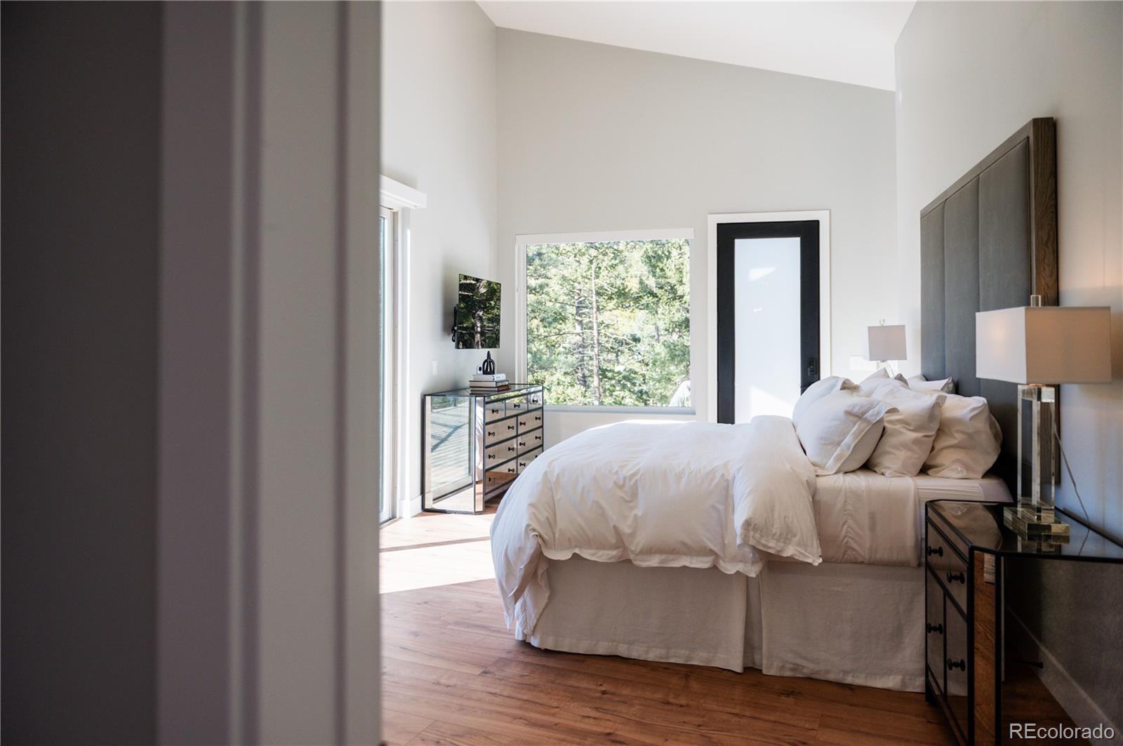 7231 Timber Trail Road Evergreen, CO 80439 - Photo 13 of 34 a bedroom with a bed and a large window