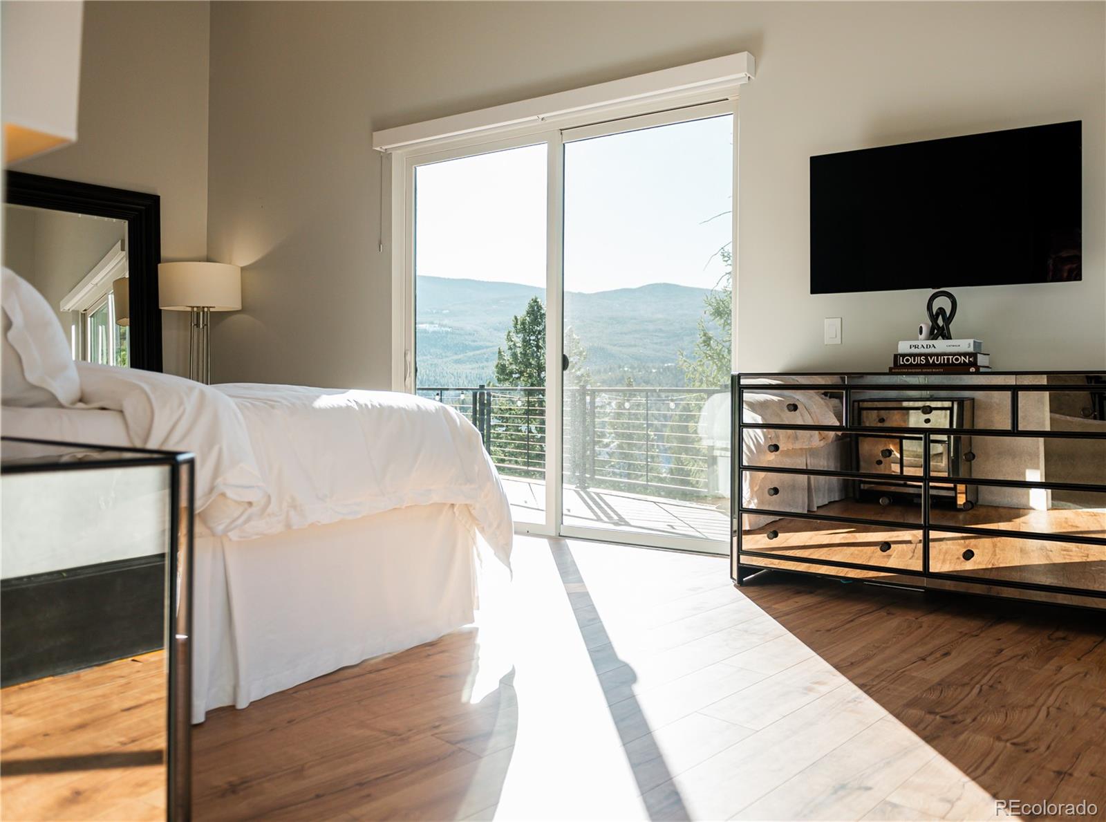 7231 Timber Trail Road Evergreen, CO 80439 - Photo 14 of 34 a bedroom with a bed and a flat screen tv