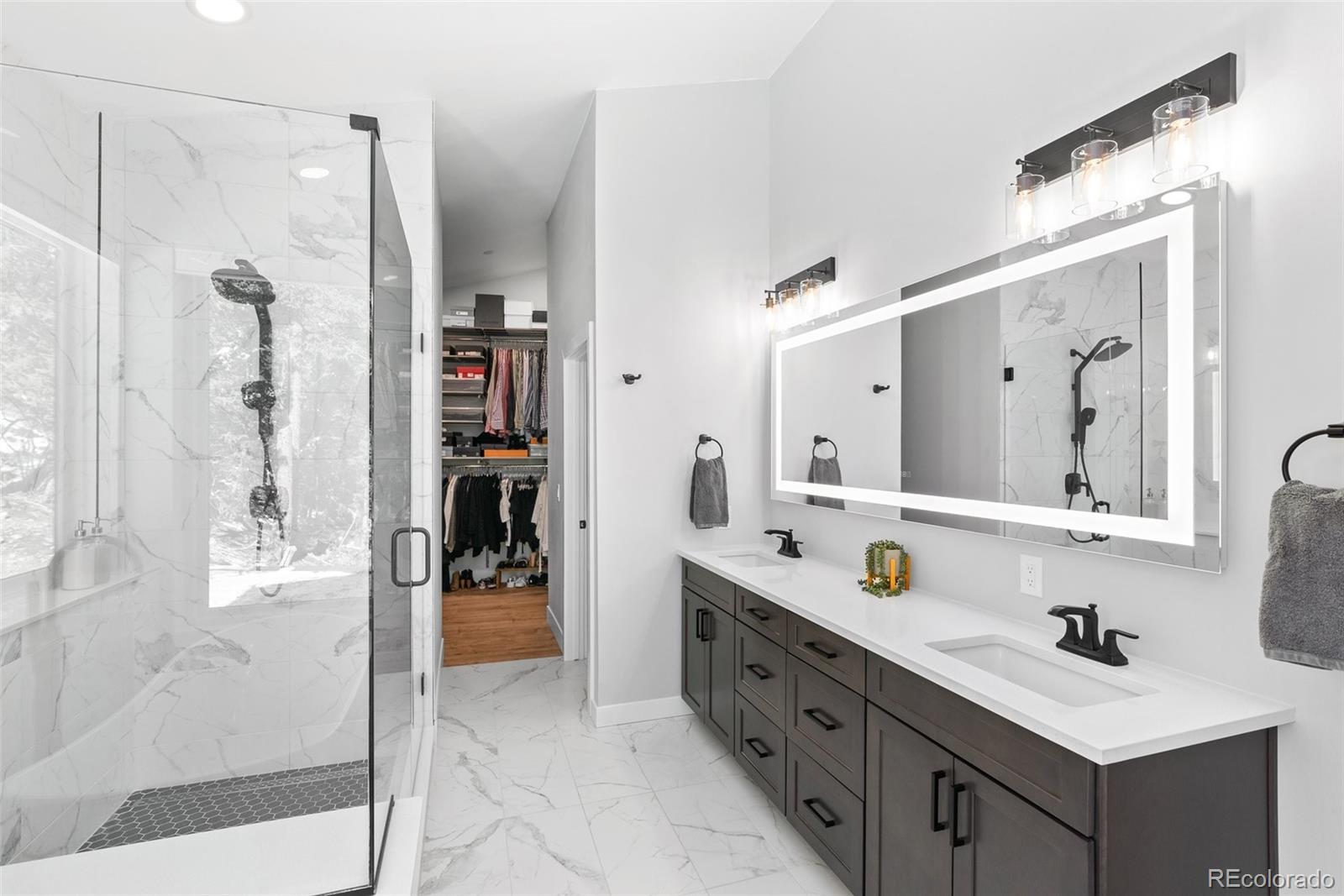 7231 Timber Trail Road Evergreen, CO 80439 - Photo 17 of 34 a spacious bathroom with a double vanity sink mirror and shower