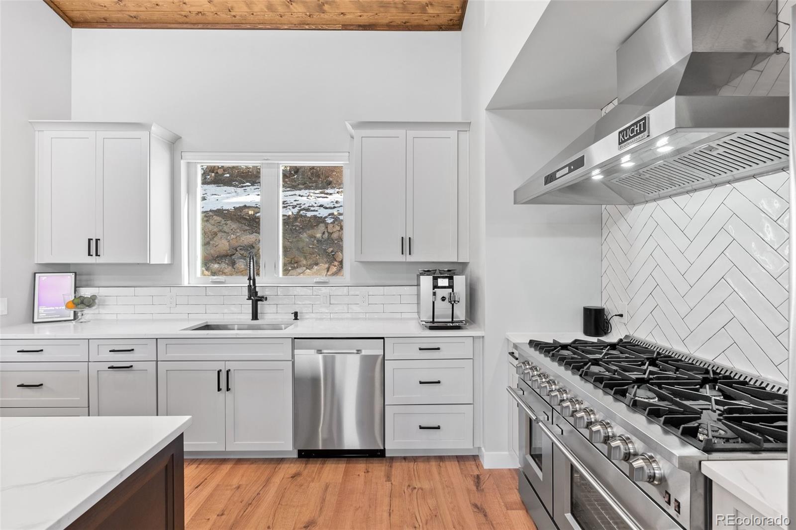 7231 Timber Trail Road Evergreen, CO 80439 - Photo 26 of 34 a kitchen with a stove a sink and wooden floor